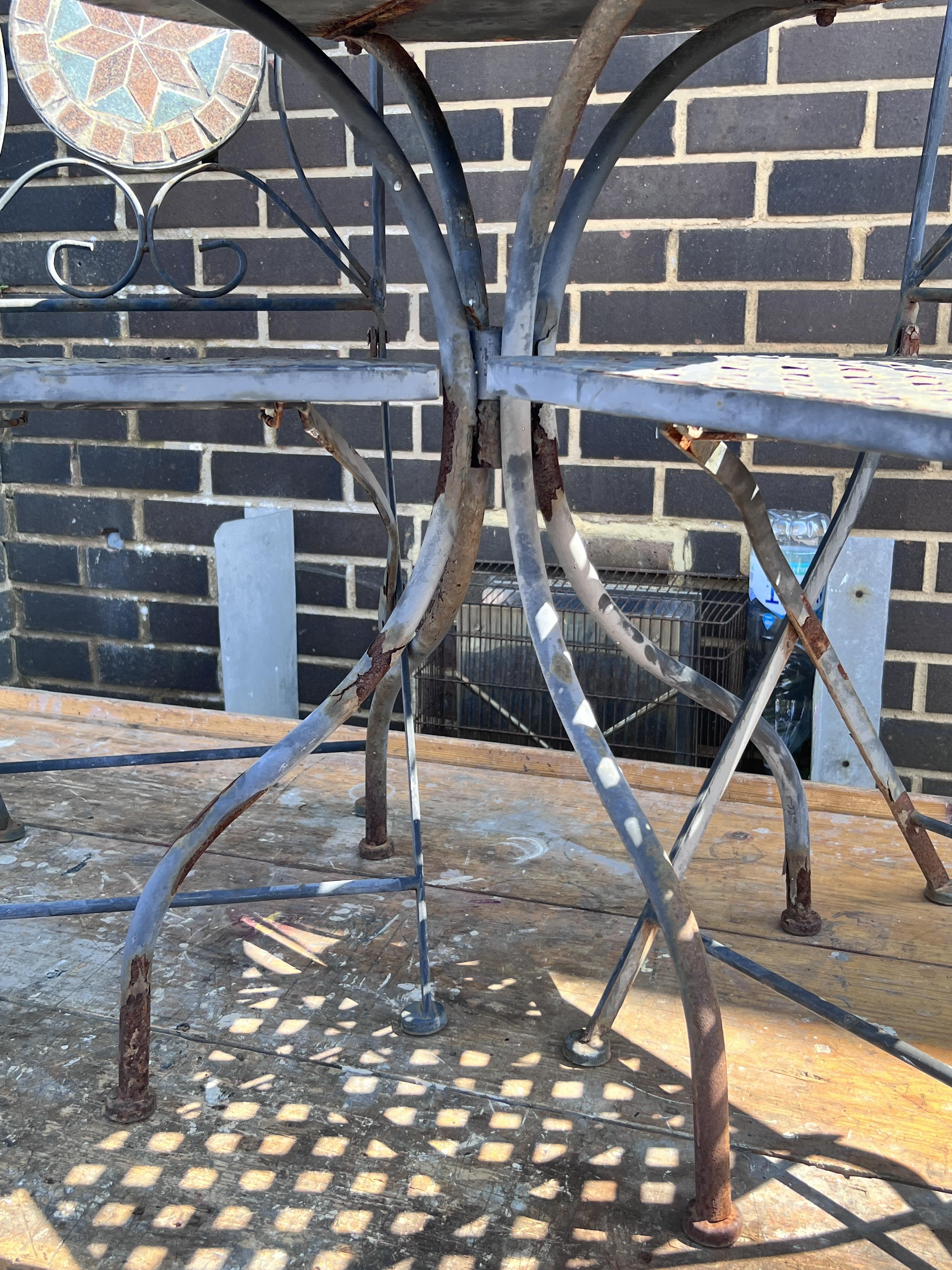 A circular mosaic topped garden table, diameter 60cm, height 73cm, and a pair of matching folding chairs